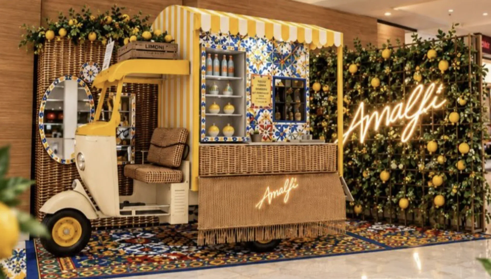 Quiosque da Amalfi decorado com limões-sicilianos, azulejos e um triciclo amarelo dentro de shopping