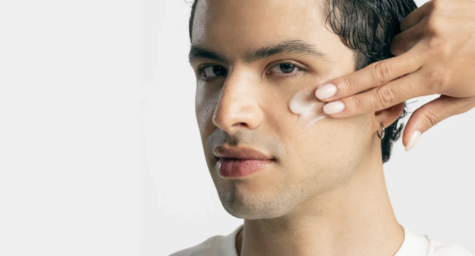 Modelo com produtos de skincare aplicados no rosto durante atendimento