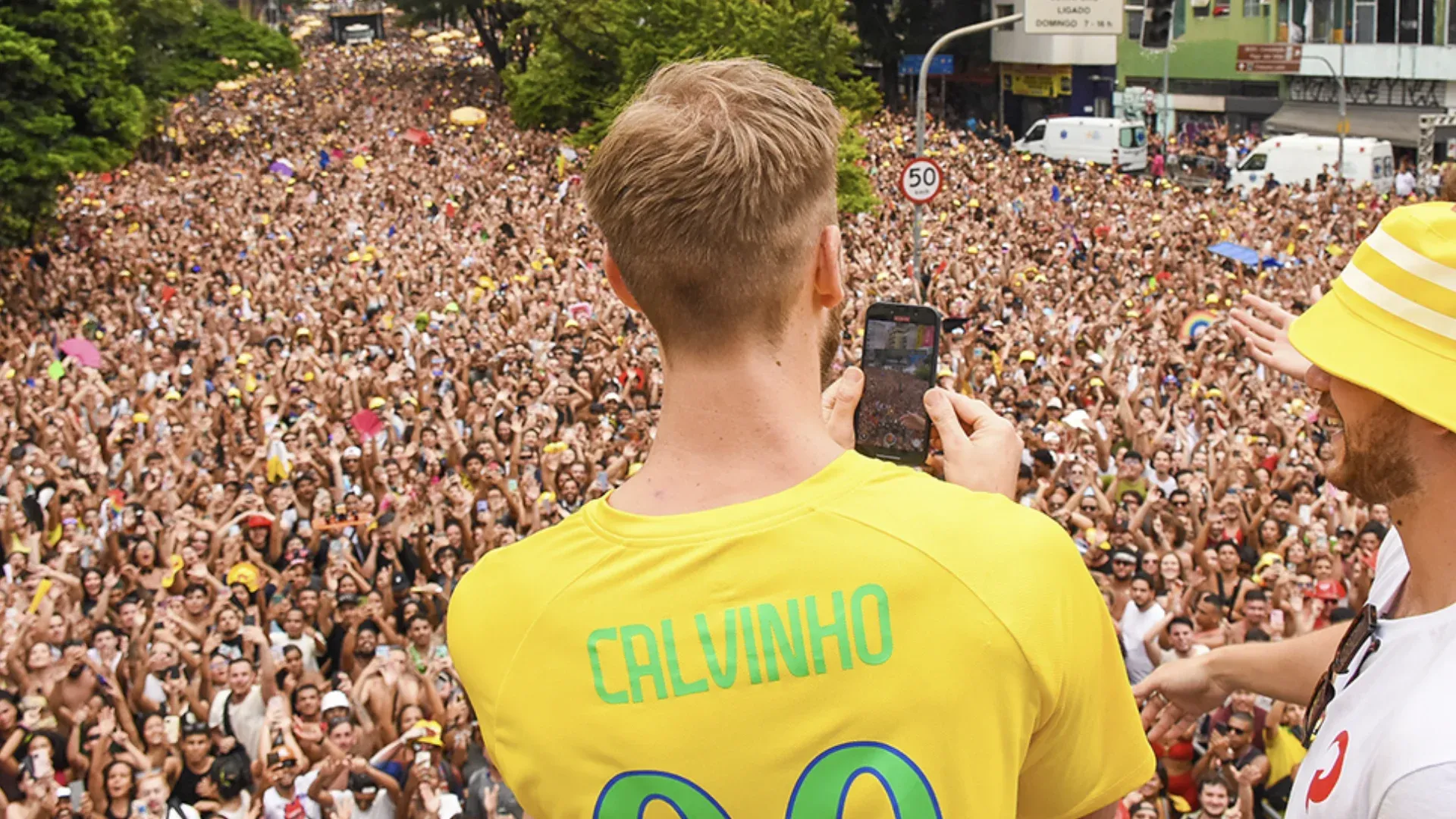 Calvin Harris com camisa amarela diante do público em apresentação anterior no Brasil