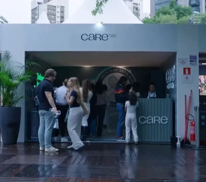 Estande da CARE Natural Beauty no SP Open com a máquina de garra, raquetes e bolas de tênis