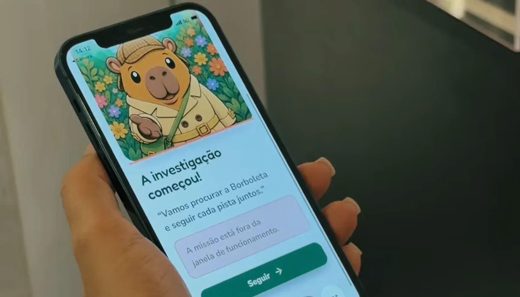 Celular com o Detetive Capi e as instruções das pistas digitais