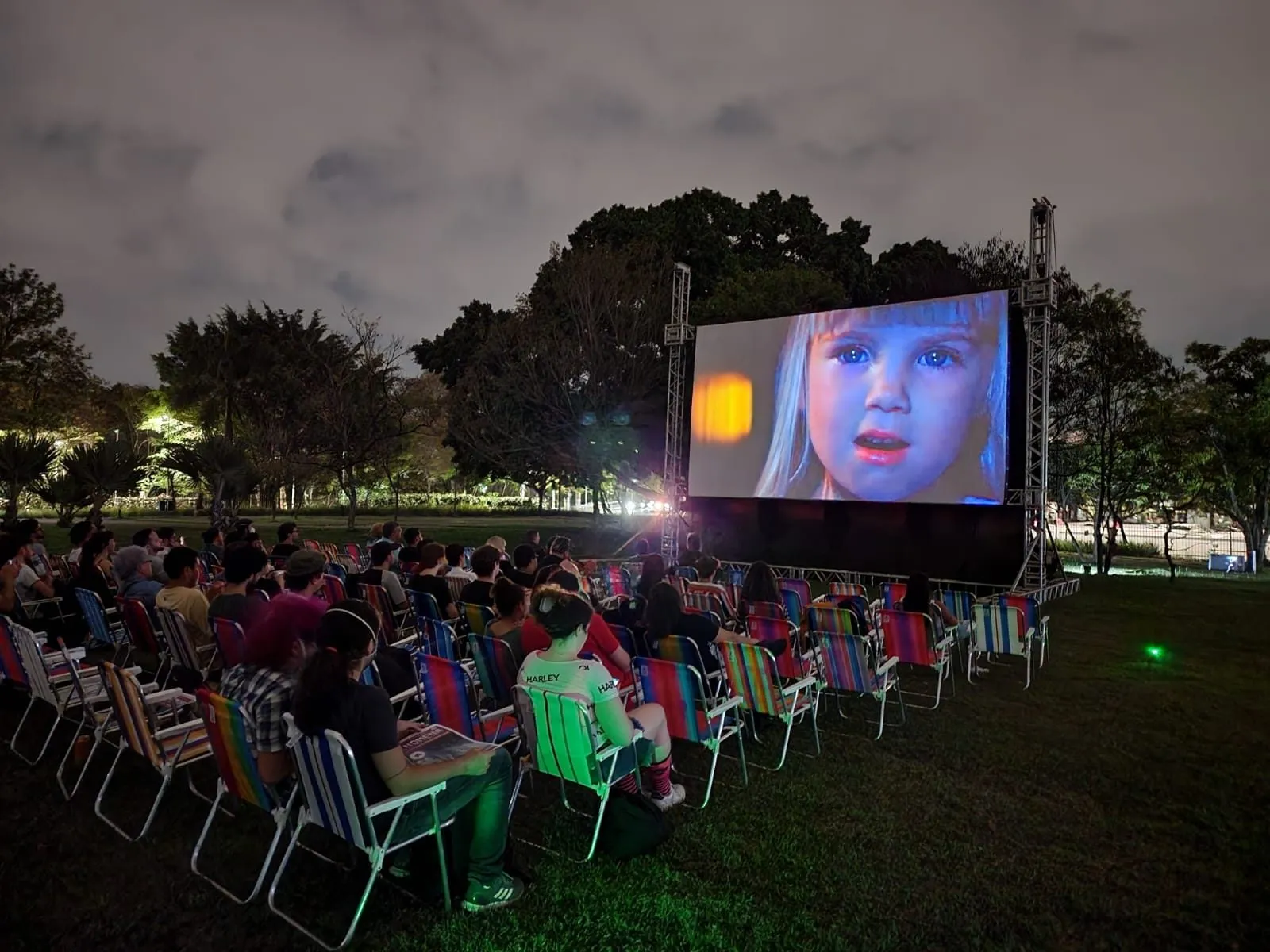 Telão montado sobre o gramado em uma edição do Cine na Praça