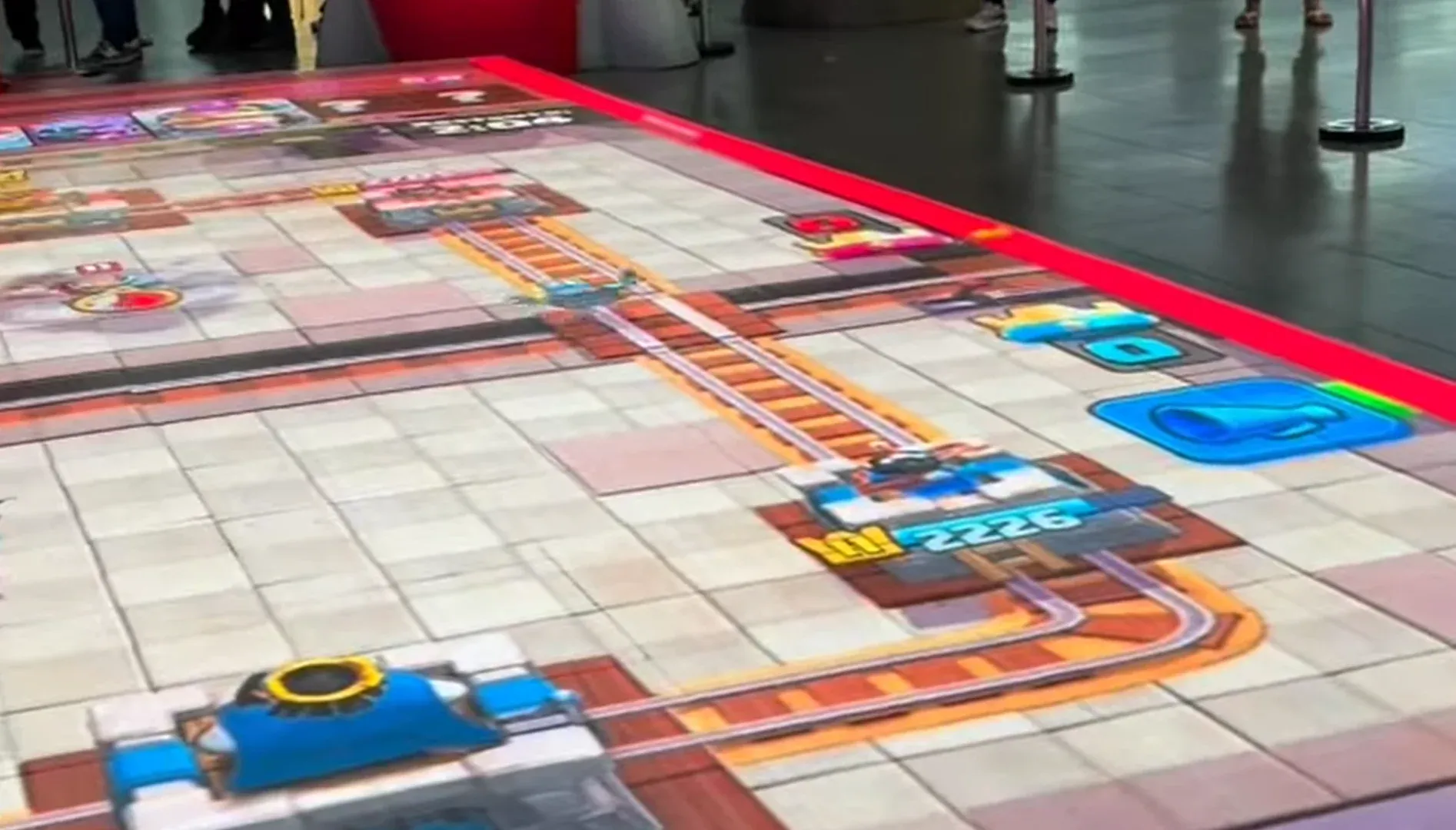 Piso de LED com o tabuleiro da arena de Clash Royale, torres e trilhos do jogo