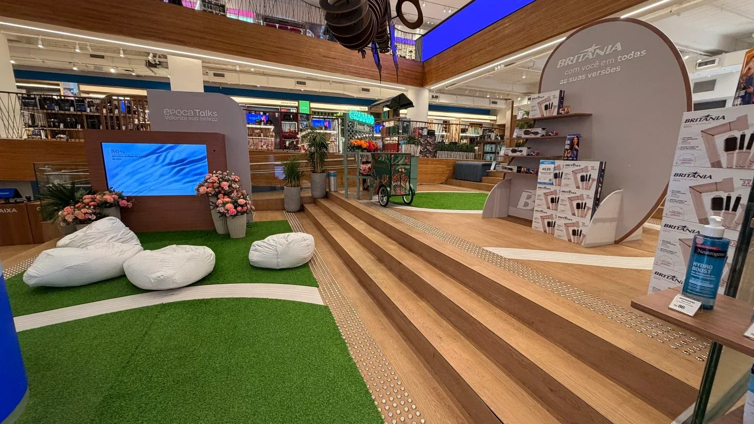 Estrutura do Circuito Bem-Estar montada na praça central da Galeria Magalu, com área de convivência e painéis da Época Cosméticos