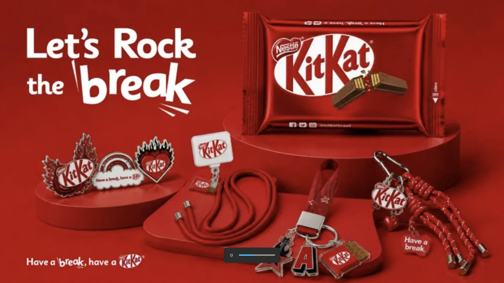 Brindes do KitKat no Rock in Rio 2026: chocolates, pins temáticos, charms e cordinhas vermelhas para celular