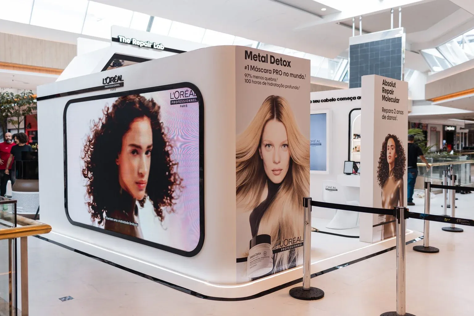 Lateral da pop-up com painéis das linhas Metal Detox e Absolut Repair Molecular e o telão da L'Oréal Professionnel