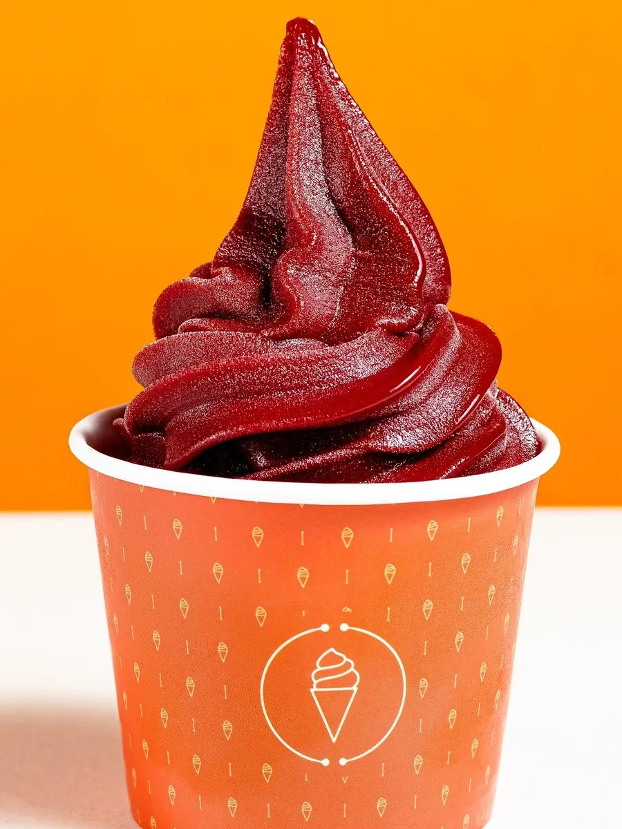 Sorvete soft vermelho de frutas no copo laranja da Luckau Soft