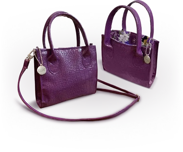 Bolsa P da promoção LUX em verniz roxo com textura de croco, alças curtas, alça transversal e pingente metálico da marca