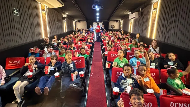 Público com pipoca nas poltronas da carreta MobiMovie Denso, em foto de divulgação do projeto