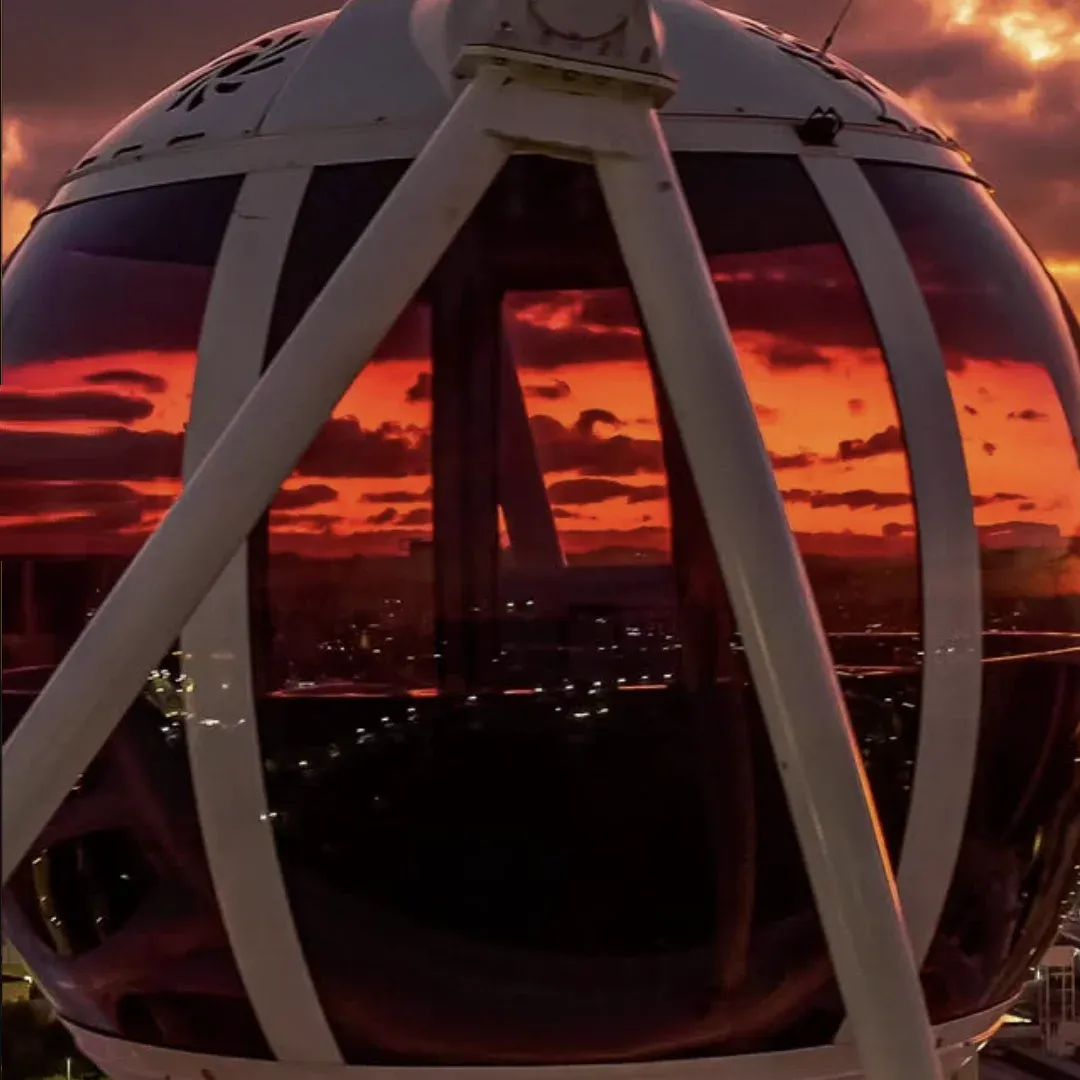 Cabine climatizada da Roda Rico com o céu alaranjado do pôr do sol refletido no vidro